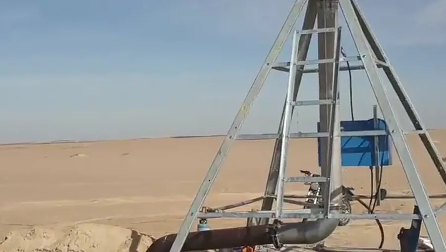 The span truss of an AksuPivot machine seen from below over bare desert ground