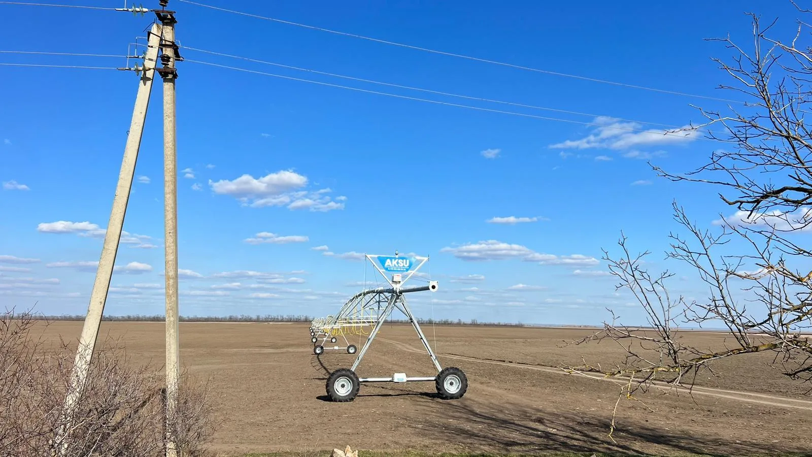 An AksuPivot pivot point standing on a bare Konya field, with a power line pole in front