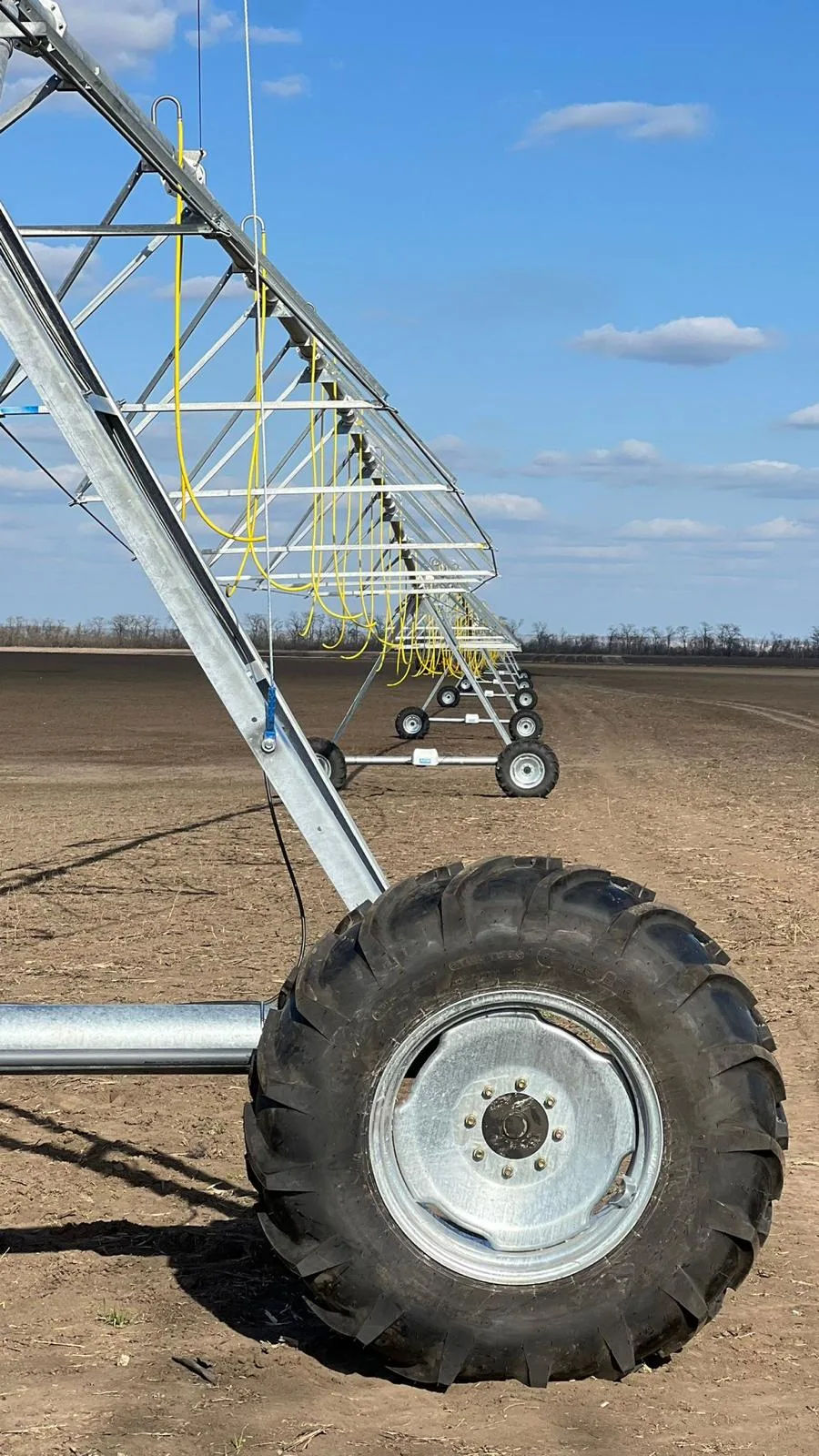 A drive tower wheel of an AksuPivot machine, with the span and drop hoses running back